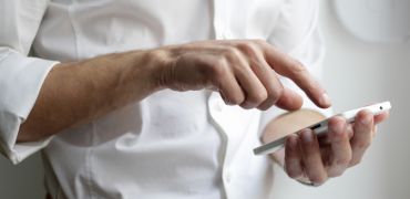 Photographie d'un homme appuyant sur son téléphone portable